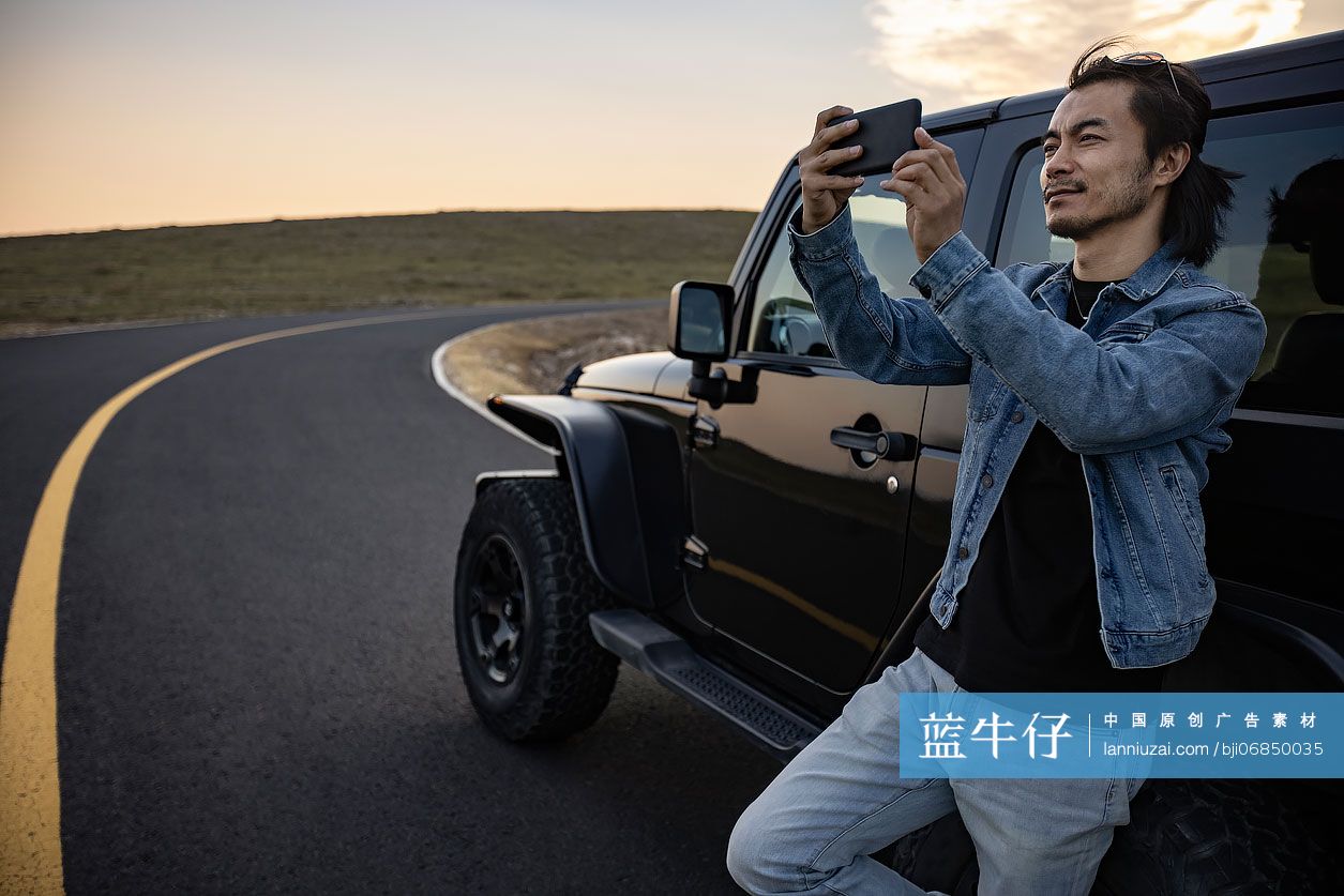 快乐男子用手机拍摄美景