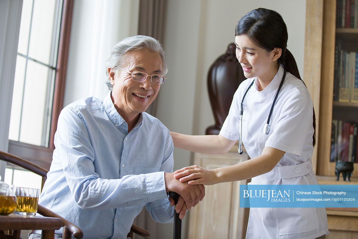 Chinese nursing assistant taking care of senior man
