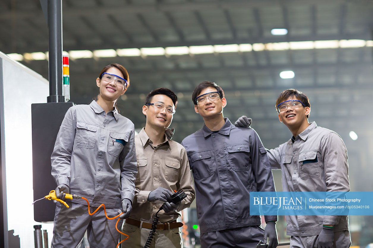 Confident Chinese engineering team in the factory