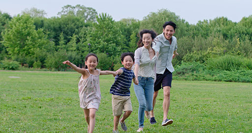 Happy young Chinese family running on grass,4K