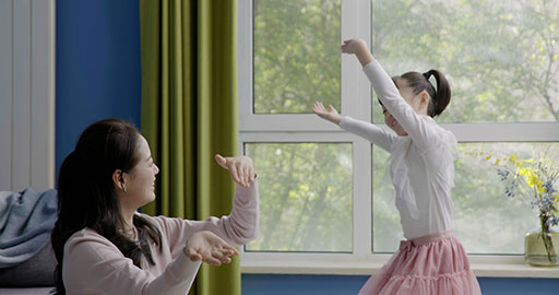 Mom and daughter dancing casually at home