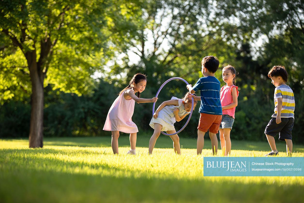 Happy Chinese children playing on meadow