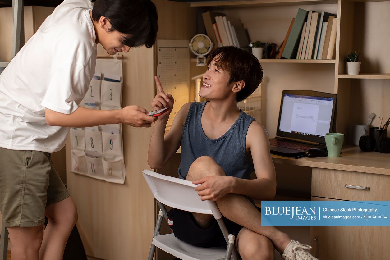 Young Chinese university students talking in dormitory