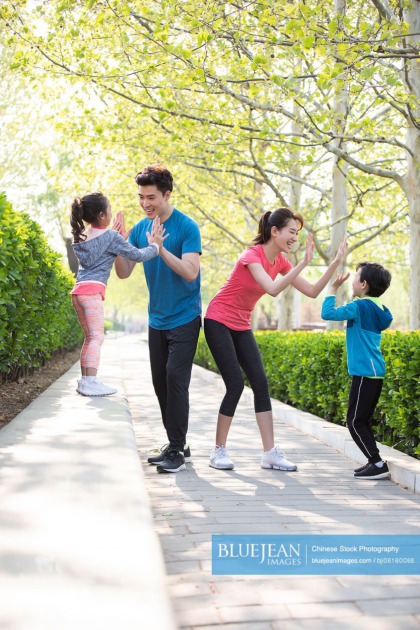 Happy young Chinese family having fun in park