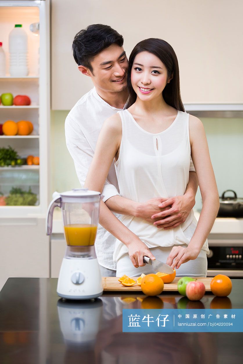 年轻夫妇在厨房切橙子