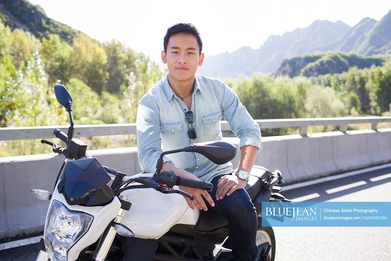 Young Chinese man riding motorcycle