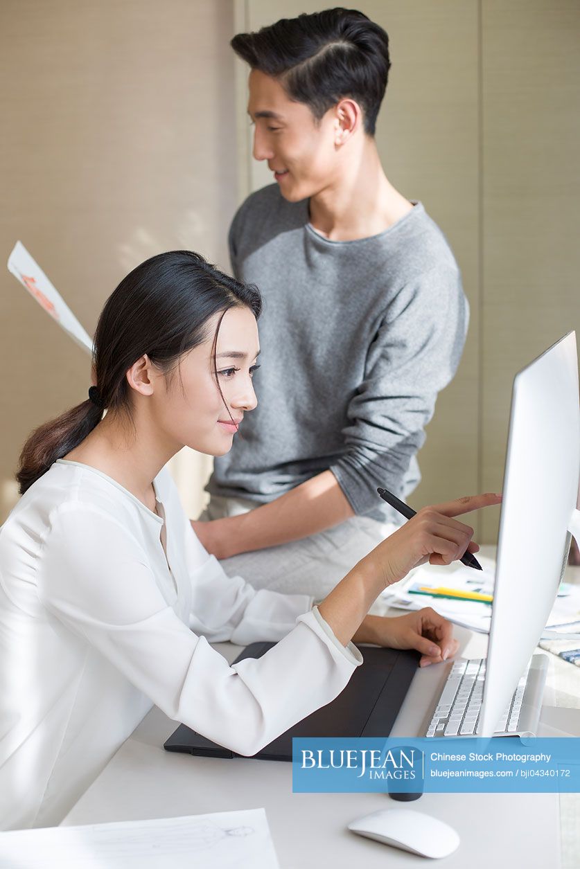 Young Chinese couple designing clothing together