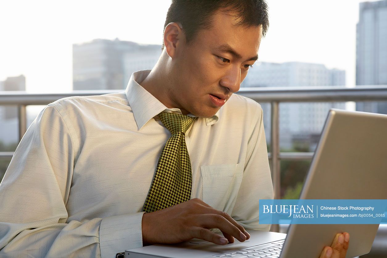 Chinese businessman working on laptop