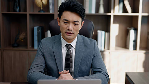 Successful Chinese businessman using laptop in office