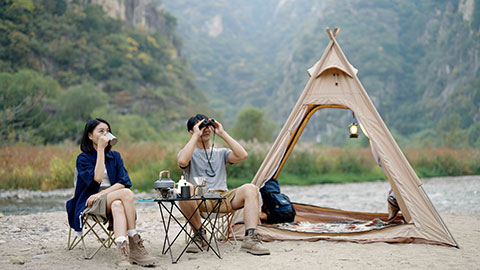 Happy young Chinese couple camping outdoors