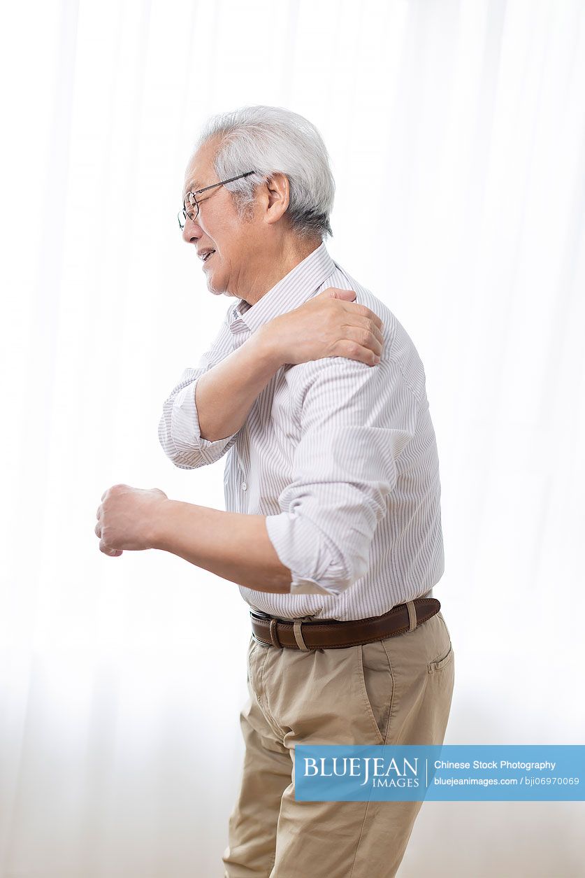 Senior Chinese man suffering from pain on shoulder