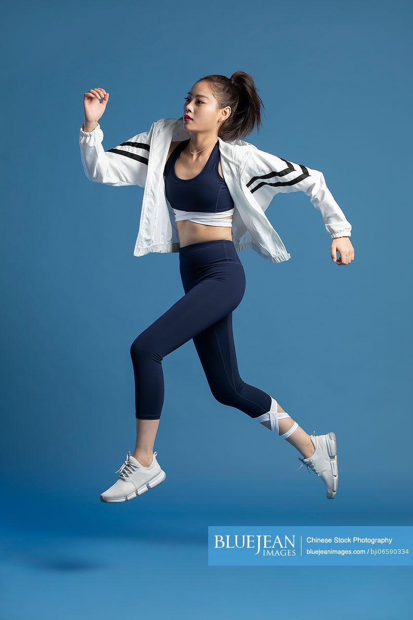 Cheerful young Chinese woman exercising