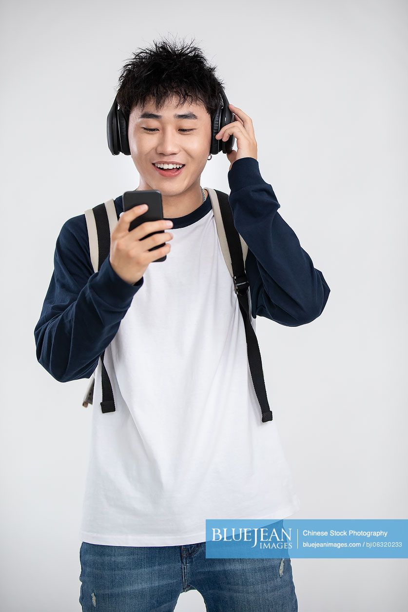 Fashionable young Chinese man listening to music