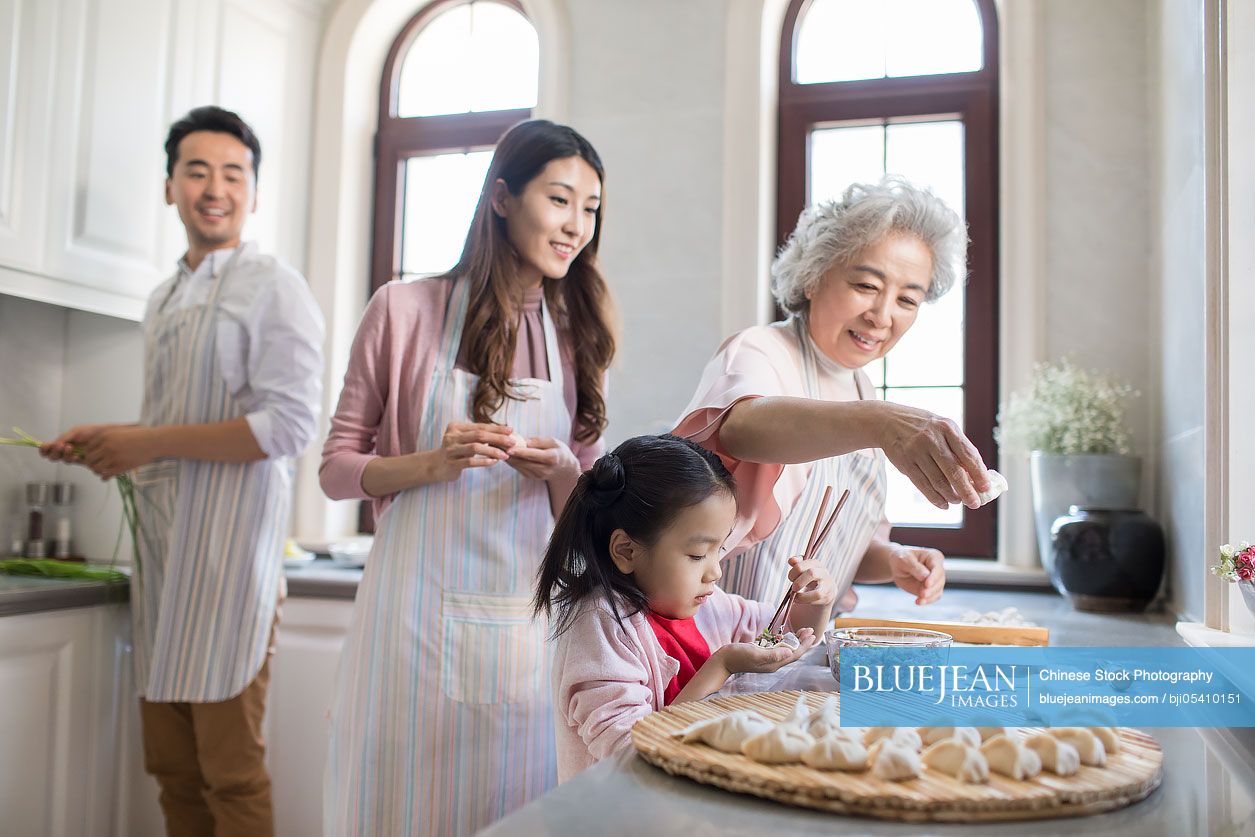 Cheerful Chinese Family Making Dumplings In Kitchen High res Stock cheerful-chinese-family-making-dumplings-in-kitchen-high-res-stock