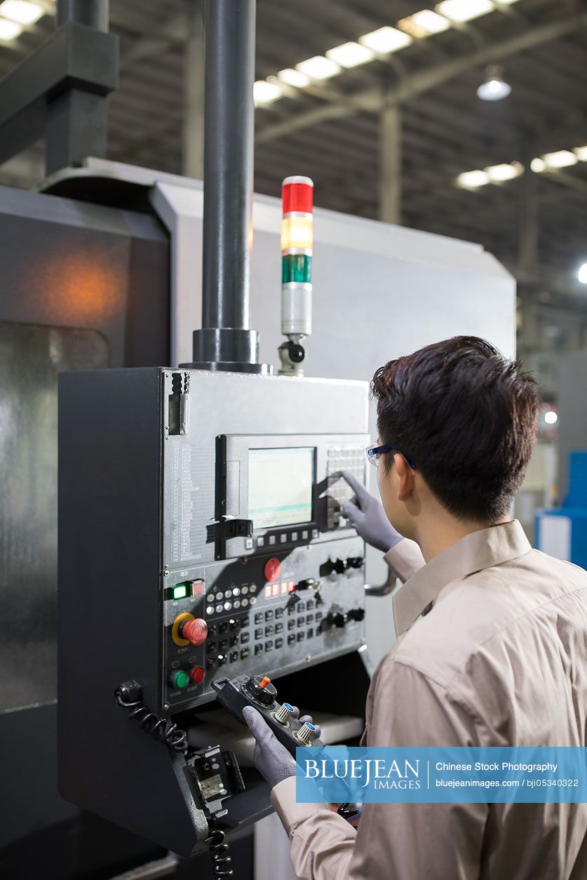 Male Chinese engineer working in the factory