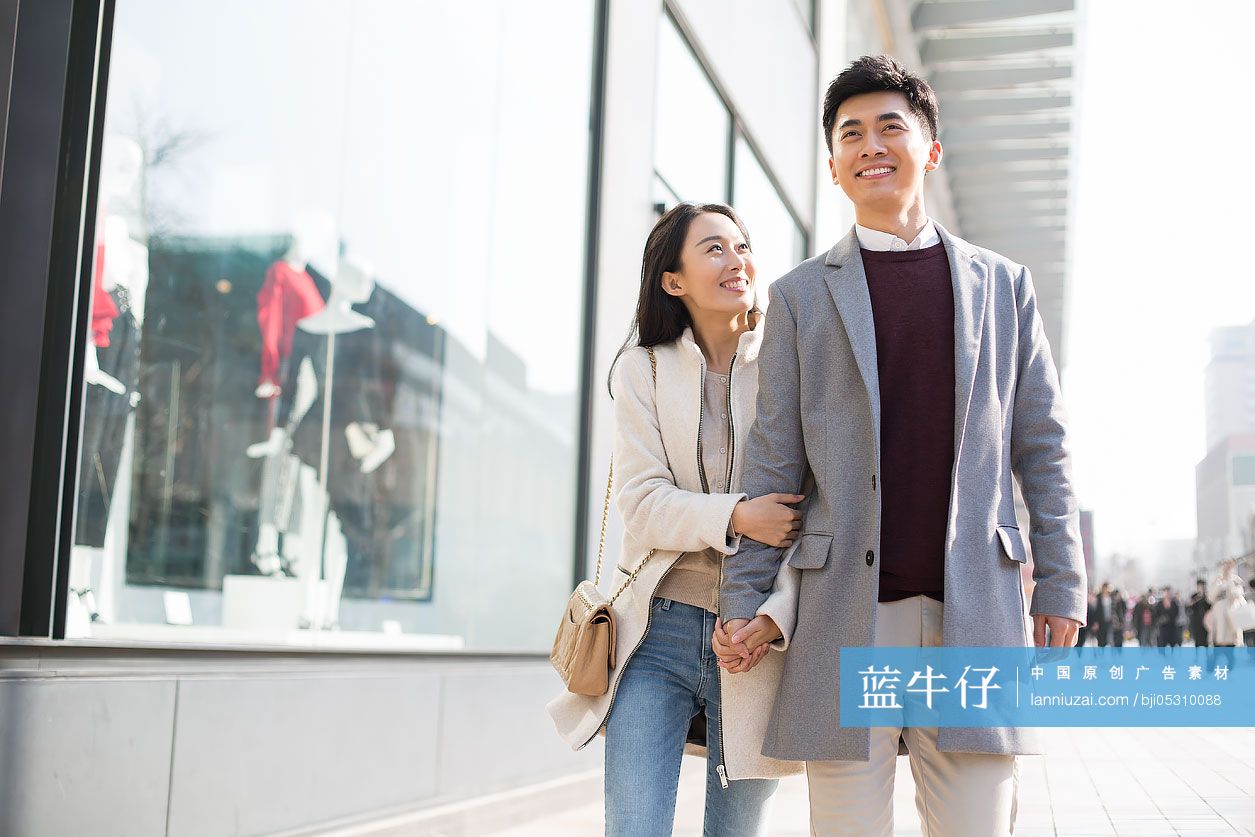 开心的年轻情侣手牵手逛街