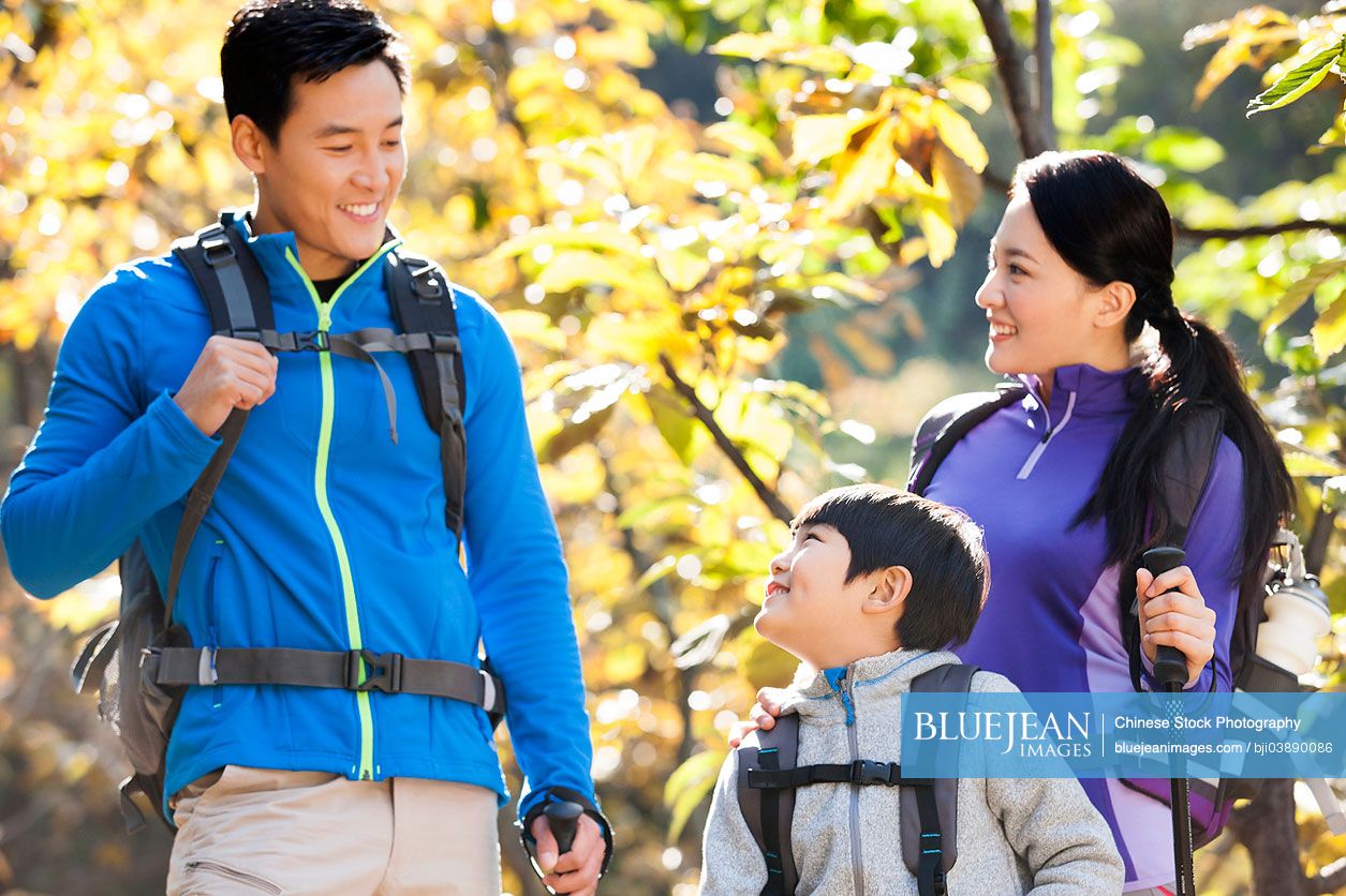 Happy Chinese family with back packs on a hike