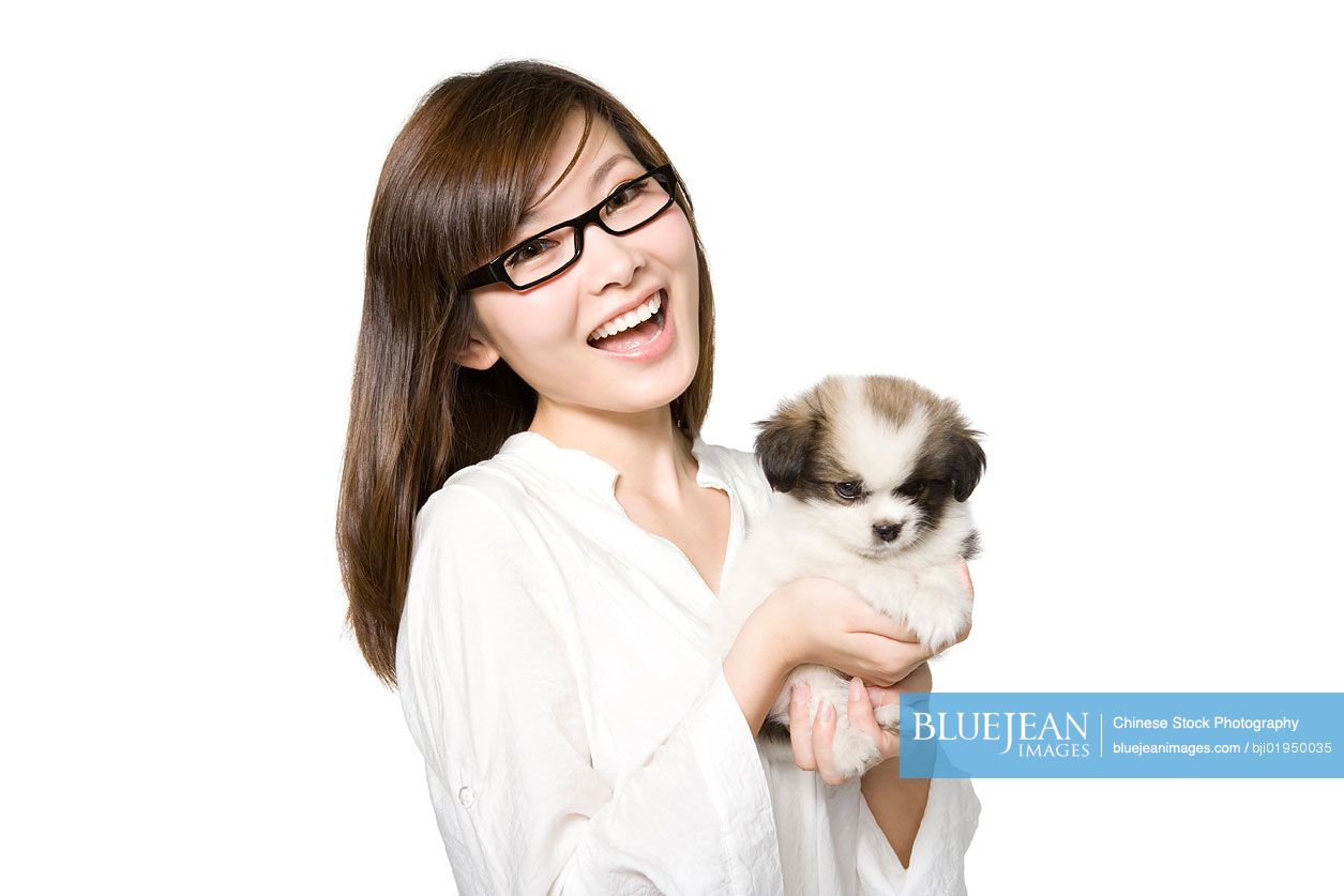 Portrait of young Chinese woman with Shih Tzu puppy