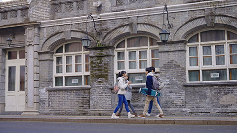 Happy Chinese college students walking and talking