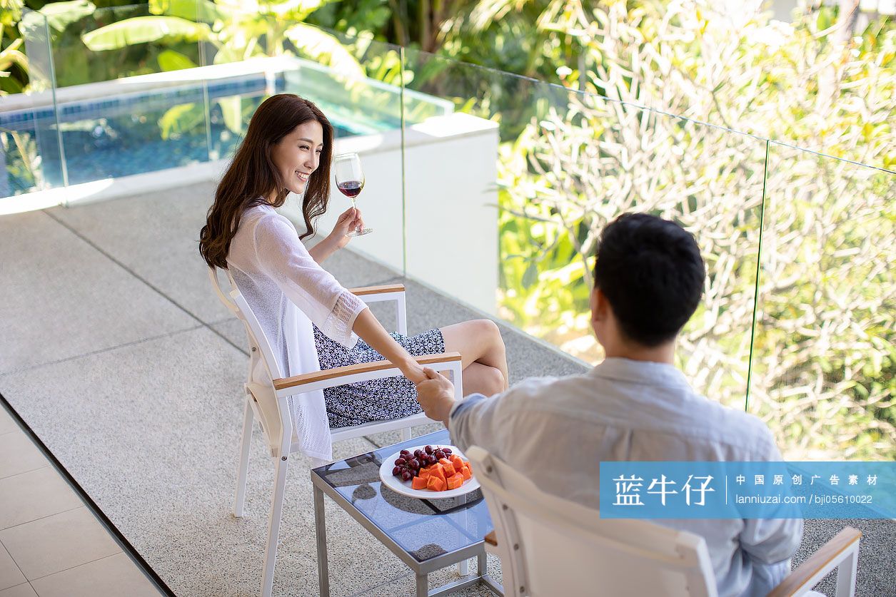 年轻夫妇在露台喝红酒