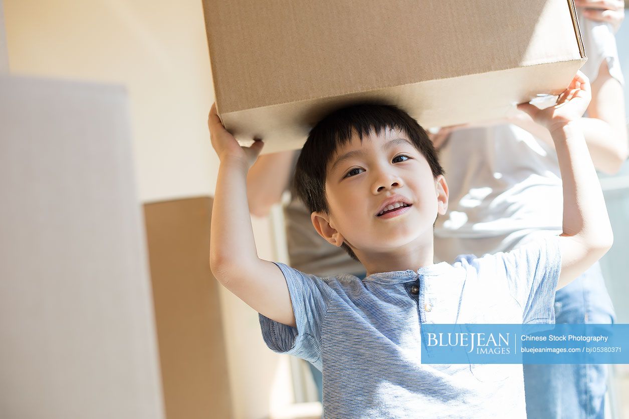 Happy young Chinese family moving to a new house