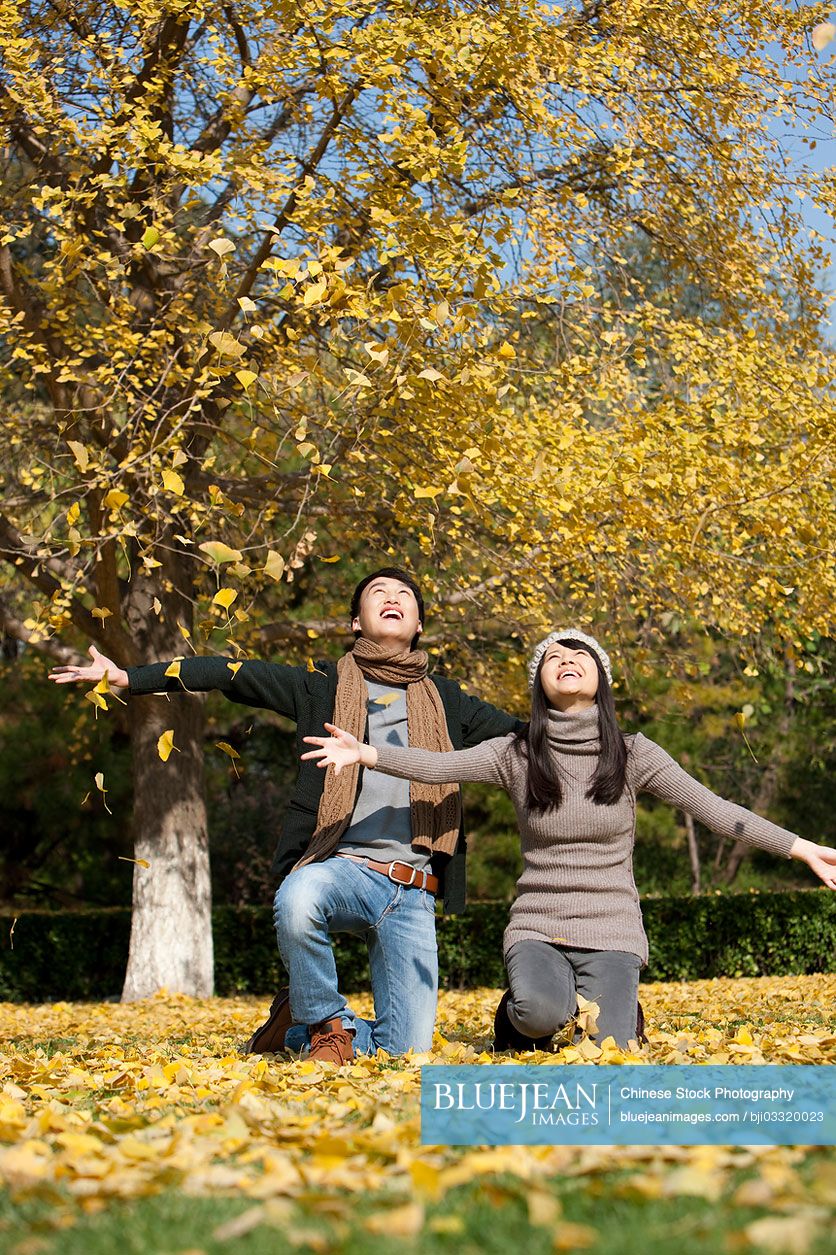 Happy young Chinese couple enjoying the pleasant view of the fall