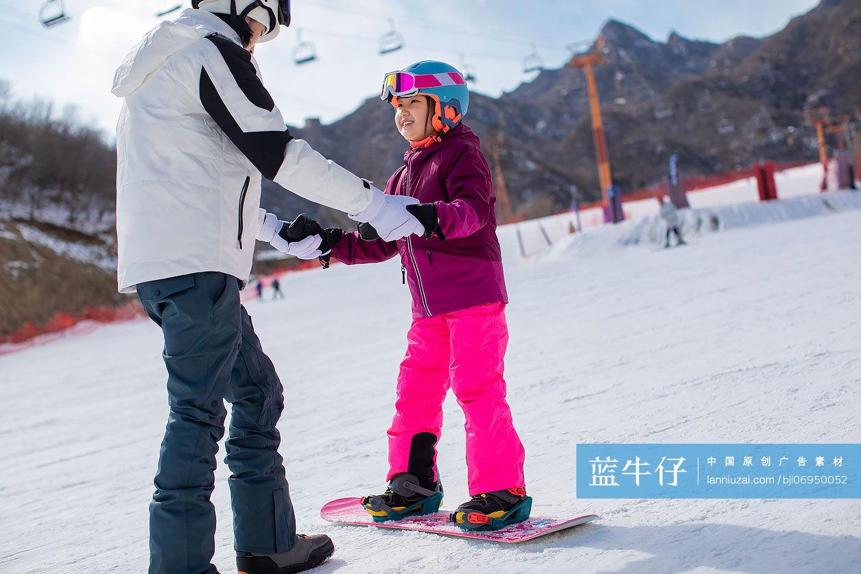 小女孩跟着教练在户外学滑雪