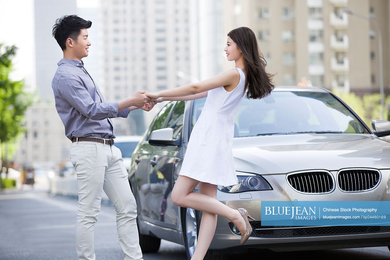 Happy young Chinese couple and car