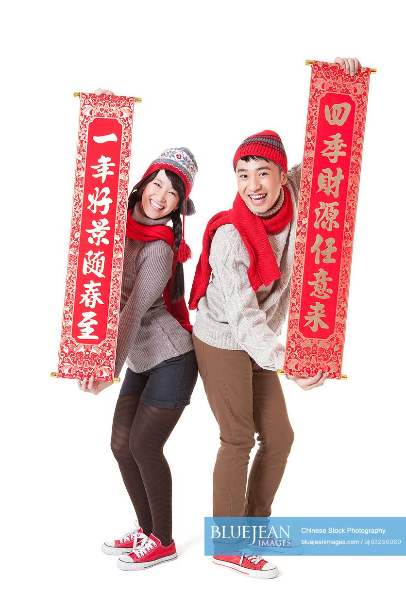 Cute young couple celebrating Chinese New Year with couplets