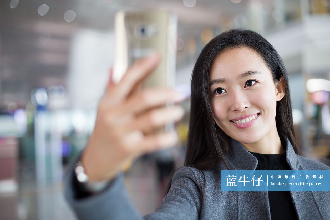 商务女士在机场用手机自拍