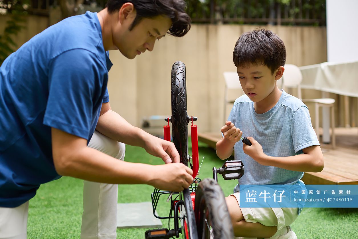 父子俩在院子里修自行车