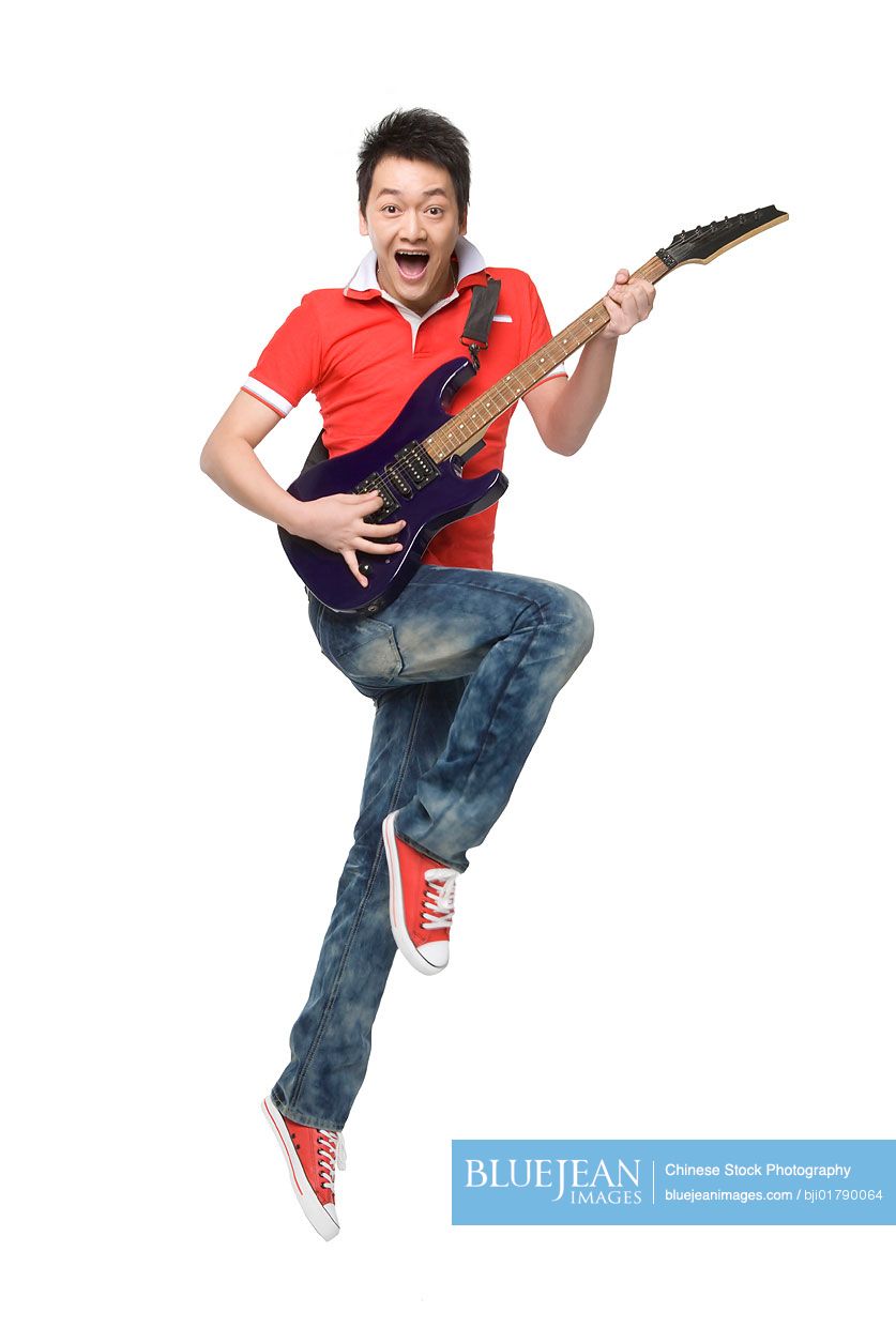 Young Chinese man playing an electric guitar