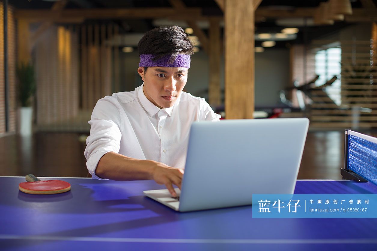 商务人士在乒乓球桌上使用笔记本电脑