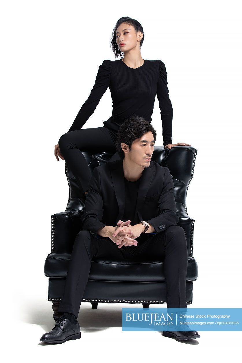 Fashionable Chinese couple sitting on a luxury sofa