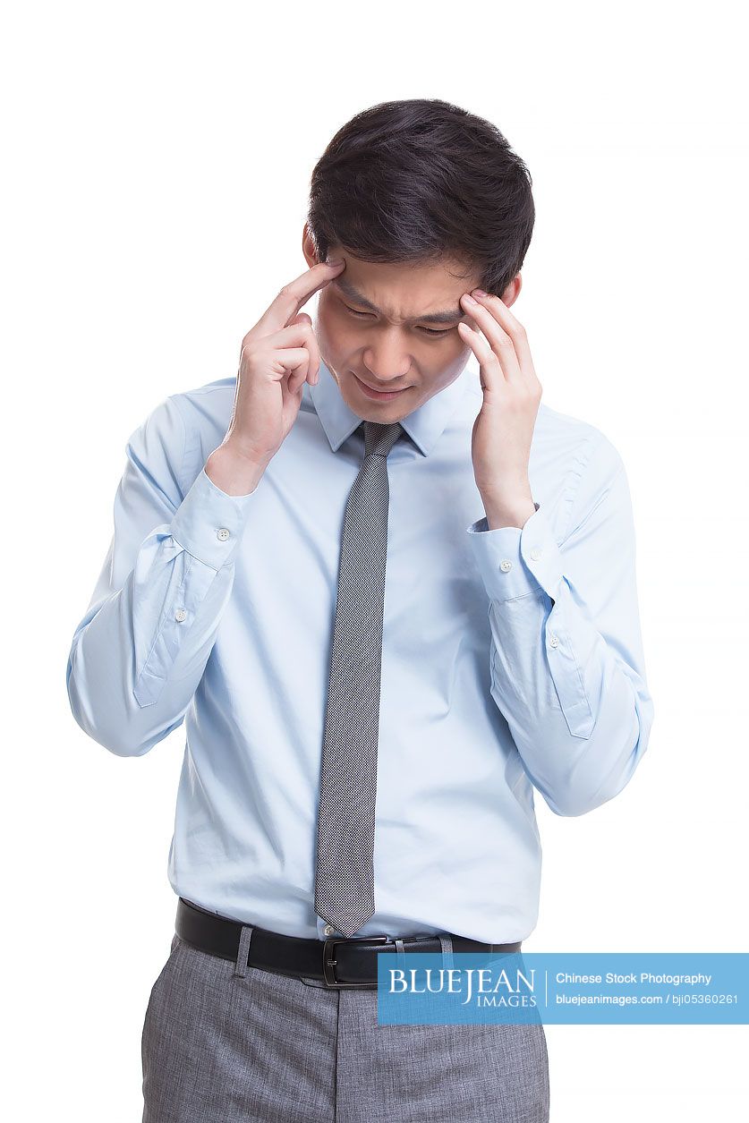 Young Chinese businessman having a headache