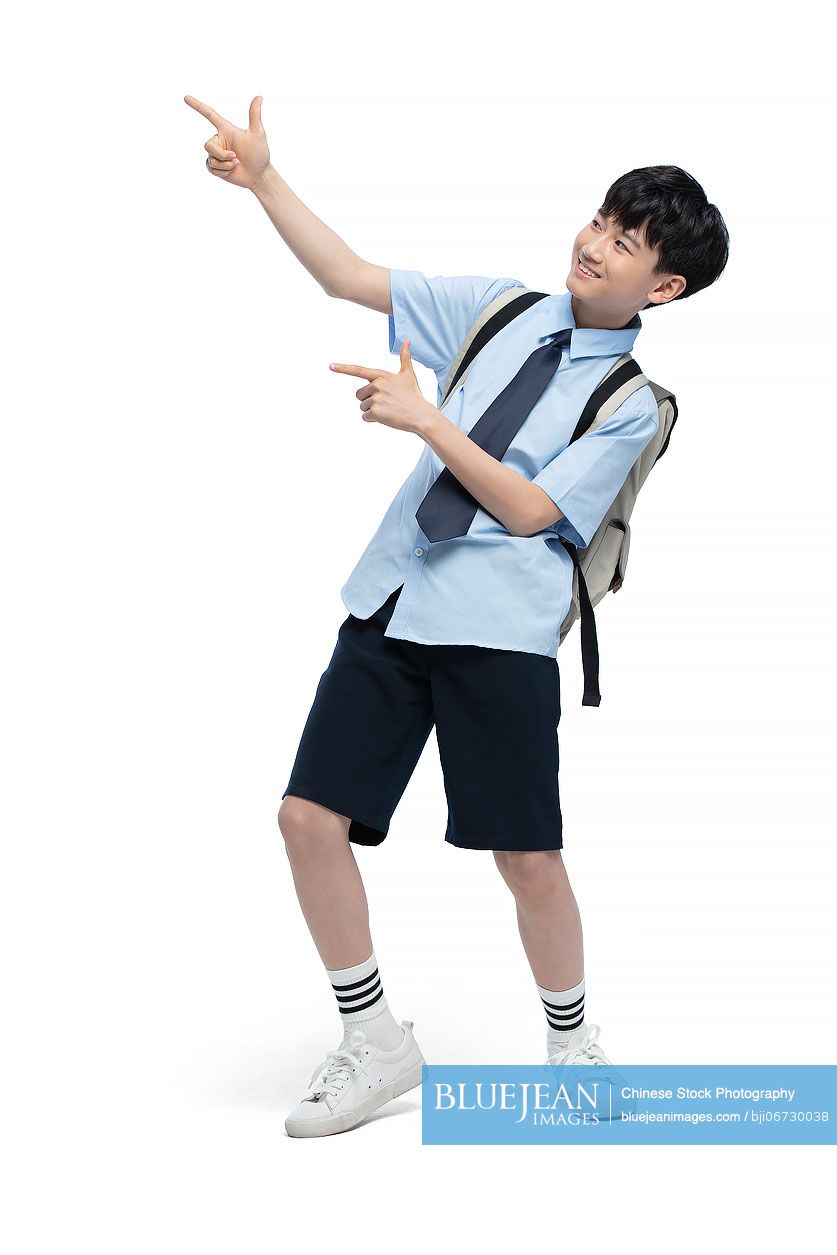 Studio shot of cheerful Chinese schoolboy