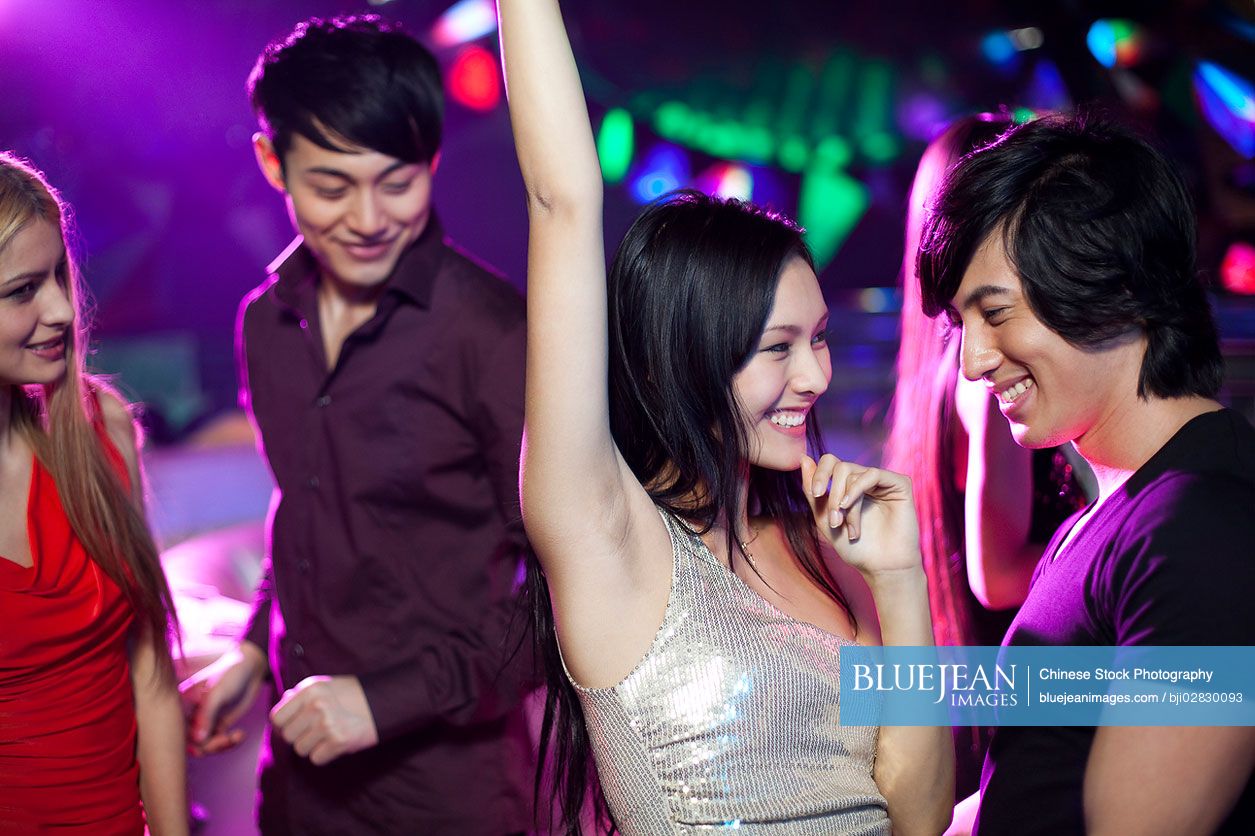 Stylish young Chinese dancing in nightclub