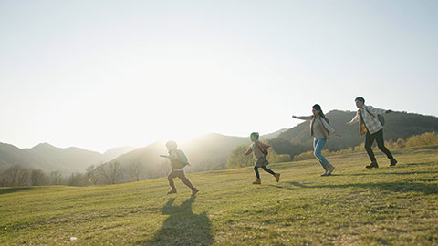 Happy young Chinese family running on the grass