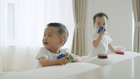 Two twin babies playing with building blocks