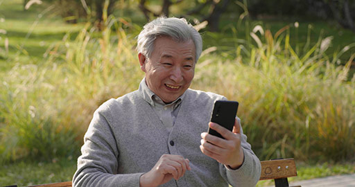 Senior Chinese man using smart phone in the park,4K