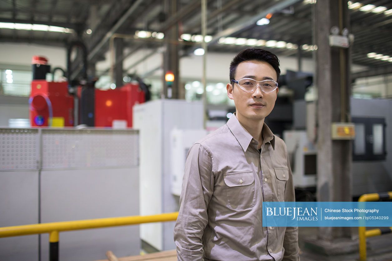 Confident Chinese engineer in the factory