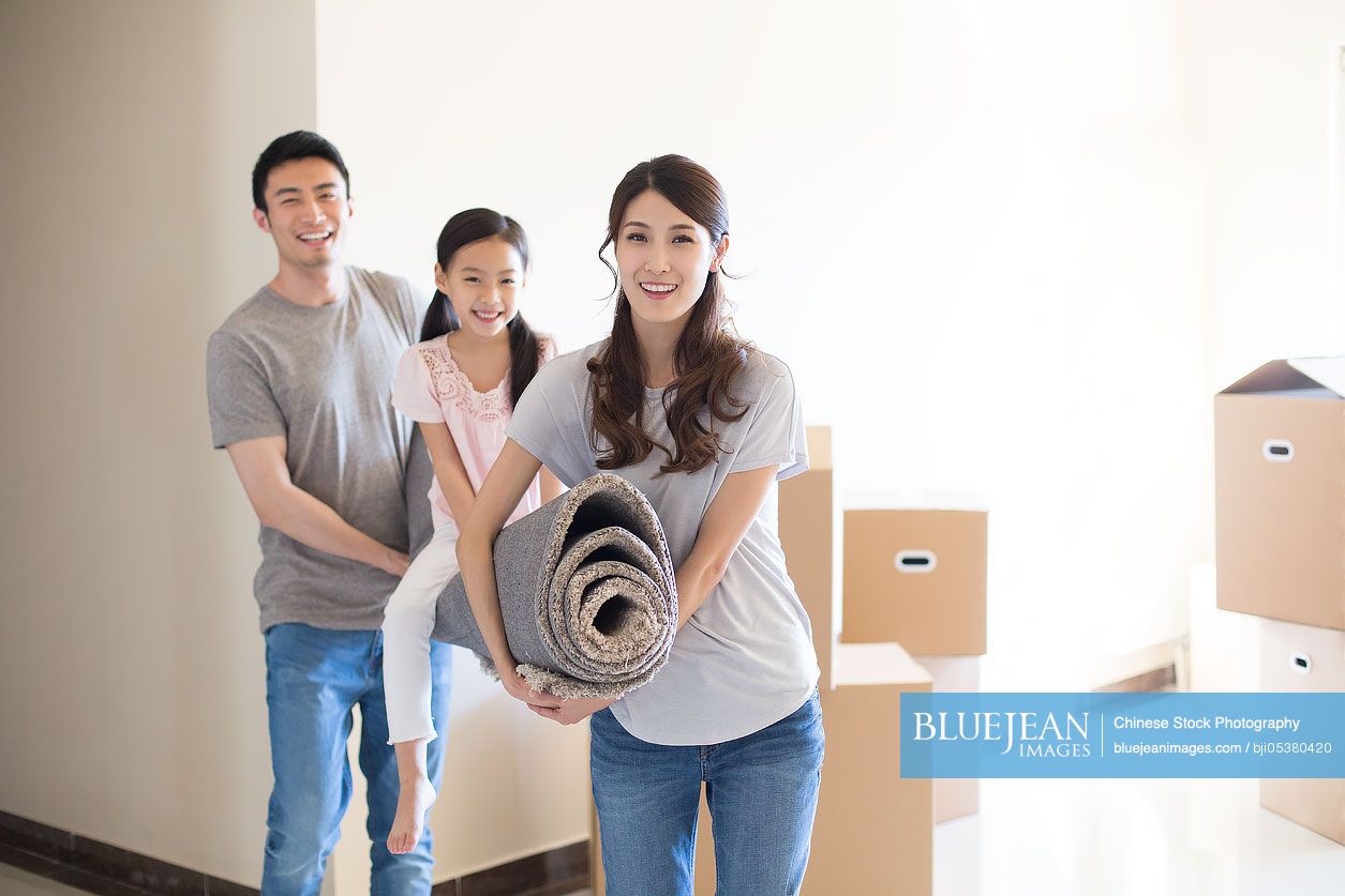 Happy Young Chinese Family Moving To A New House High res Stock Photo 