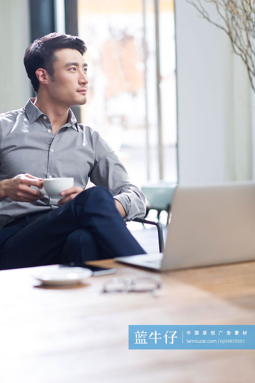 年轻商务男子在办公室喝咖啡