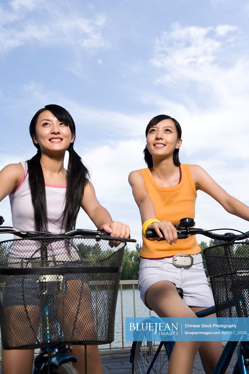 Two young Chinese friends ride their bikes