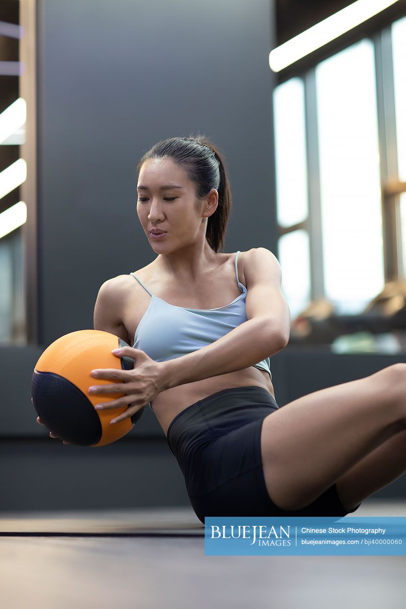 Young Chinese woman exercising at gym