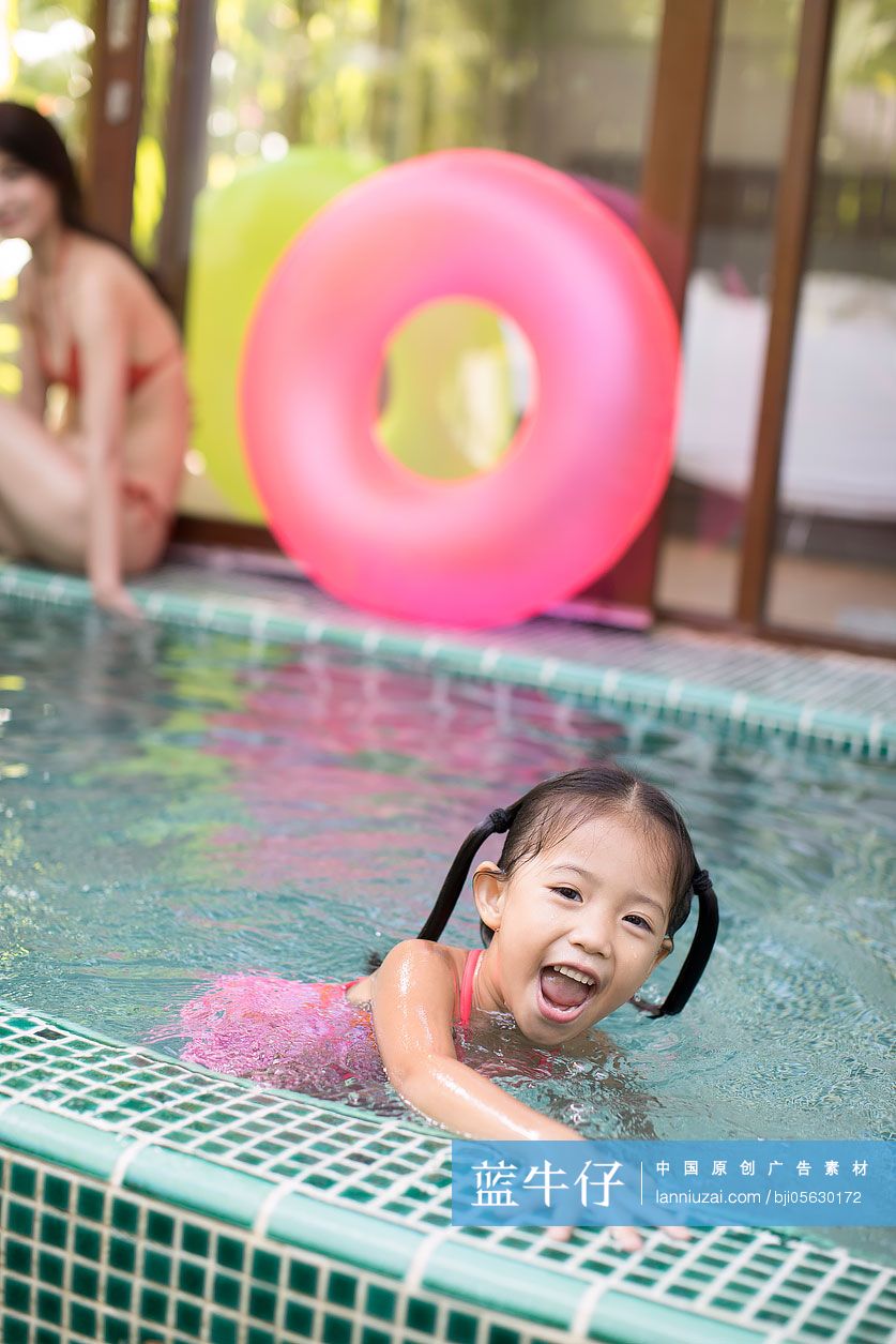 快乐的小女孩在泳池玩耍