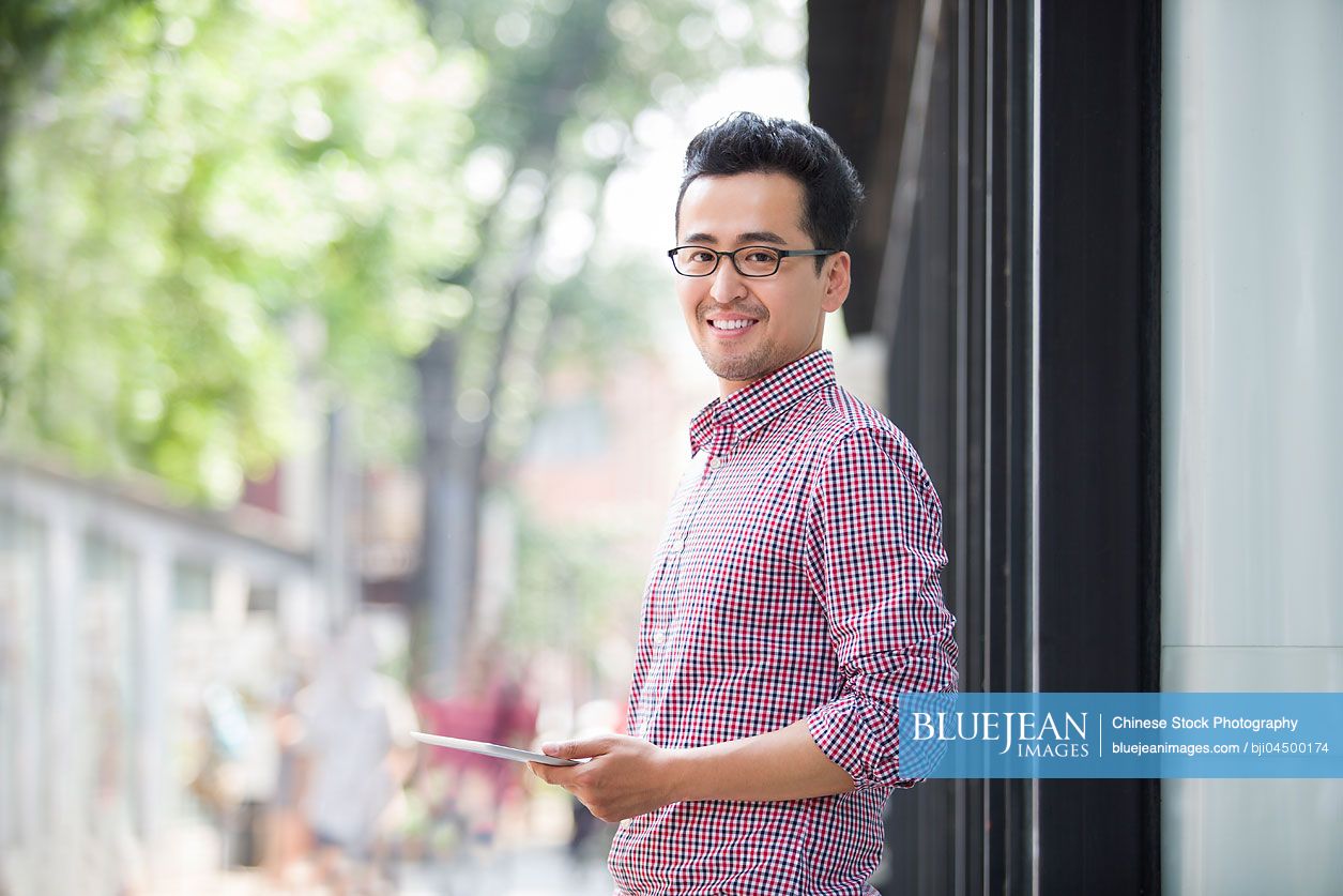 Chinese man holding a digital tablet