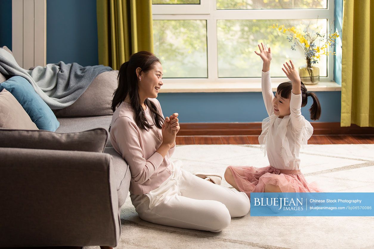 Young Chinese mother and daughter relaxing at home