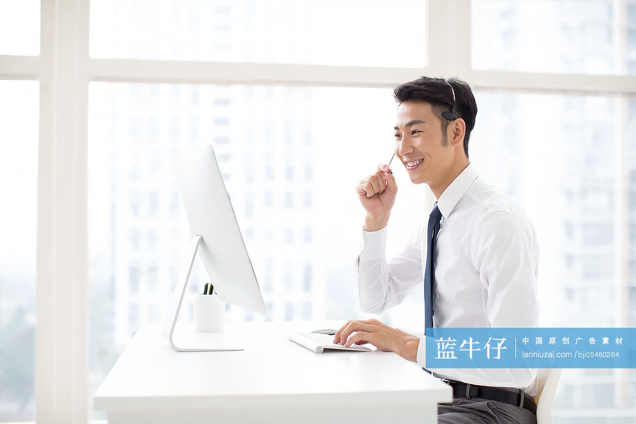 自信的年轻商务男士戴着耳麦工作