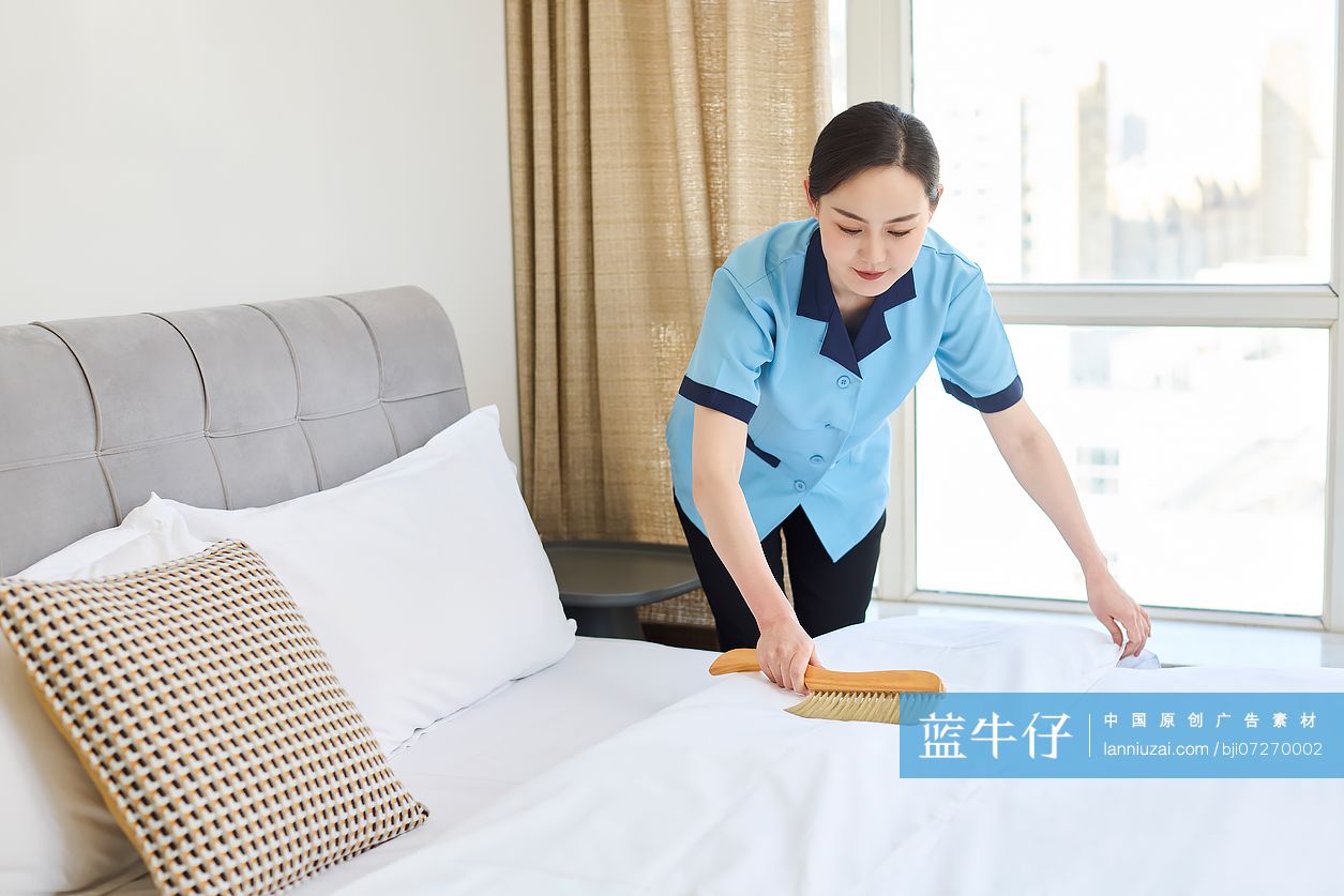 家政人员整理卧室床铺